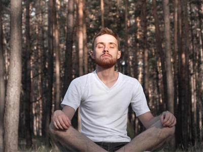 Someone taking in a large breath outdoors.